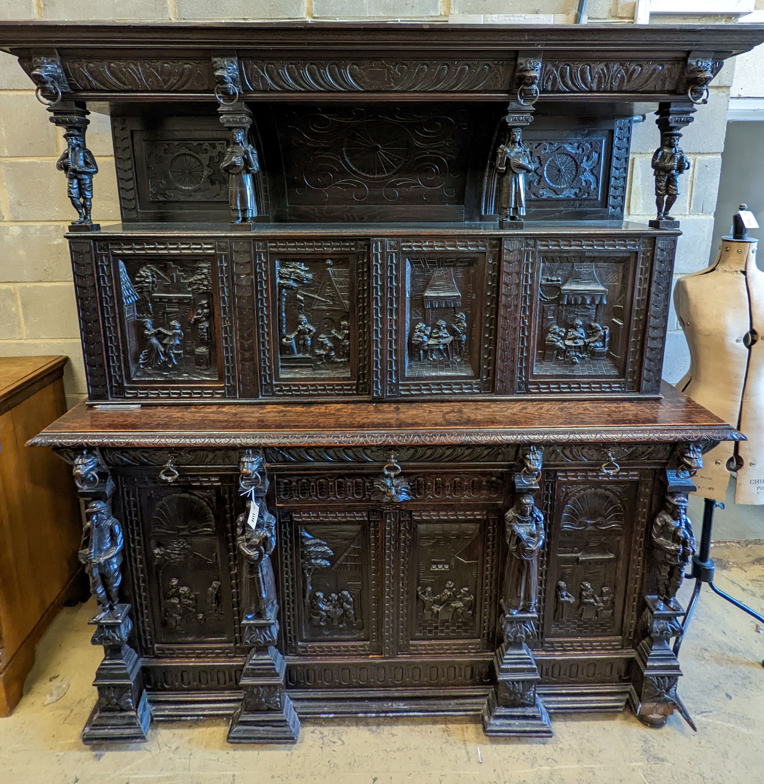 An early 20th century carved oak court cupboard in the Flemish style, length 200cm, depth 58cm, height 212cm